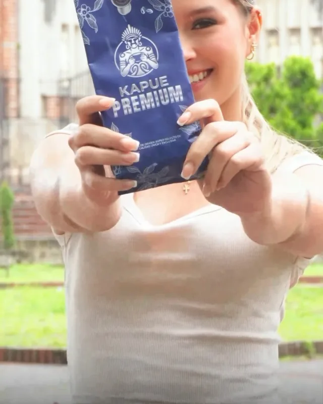 Mujer sonriendo mientras muestra a la cámara una bolsa azul de Kapue Premium.